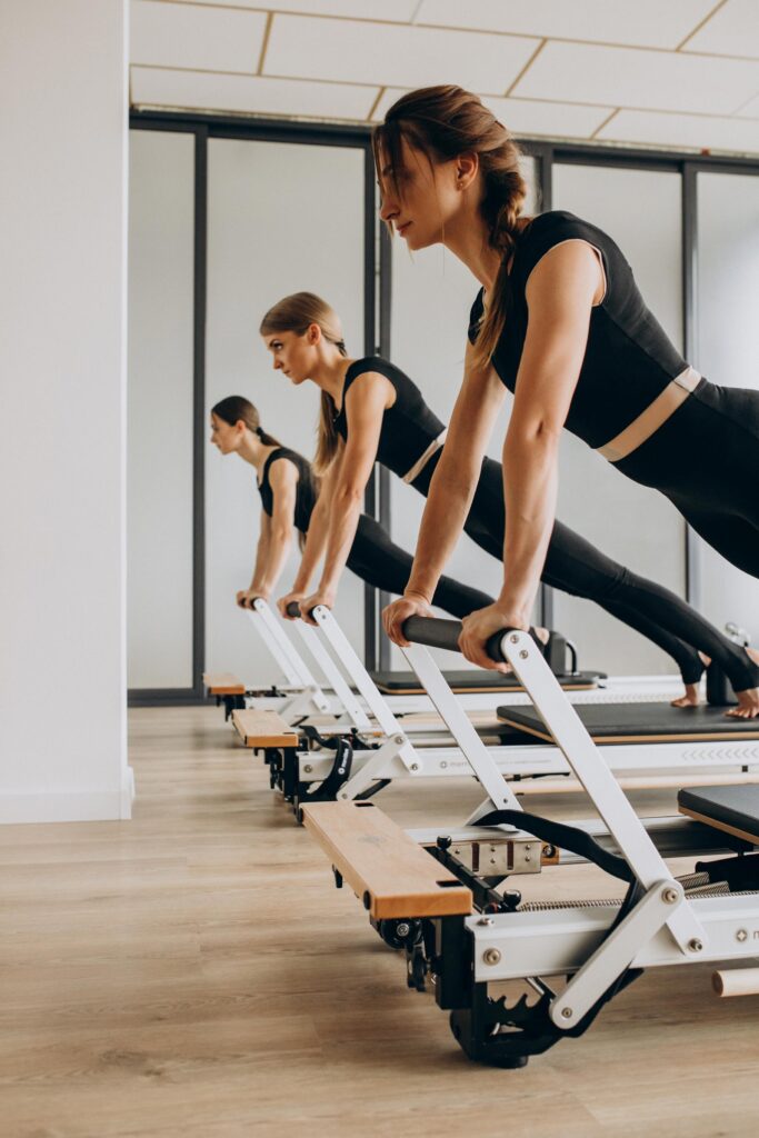 Women performing reformer pilates.