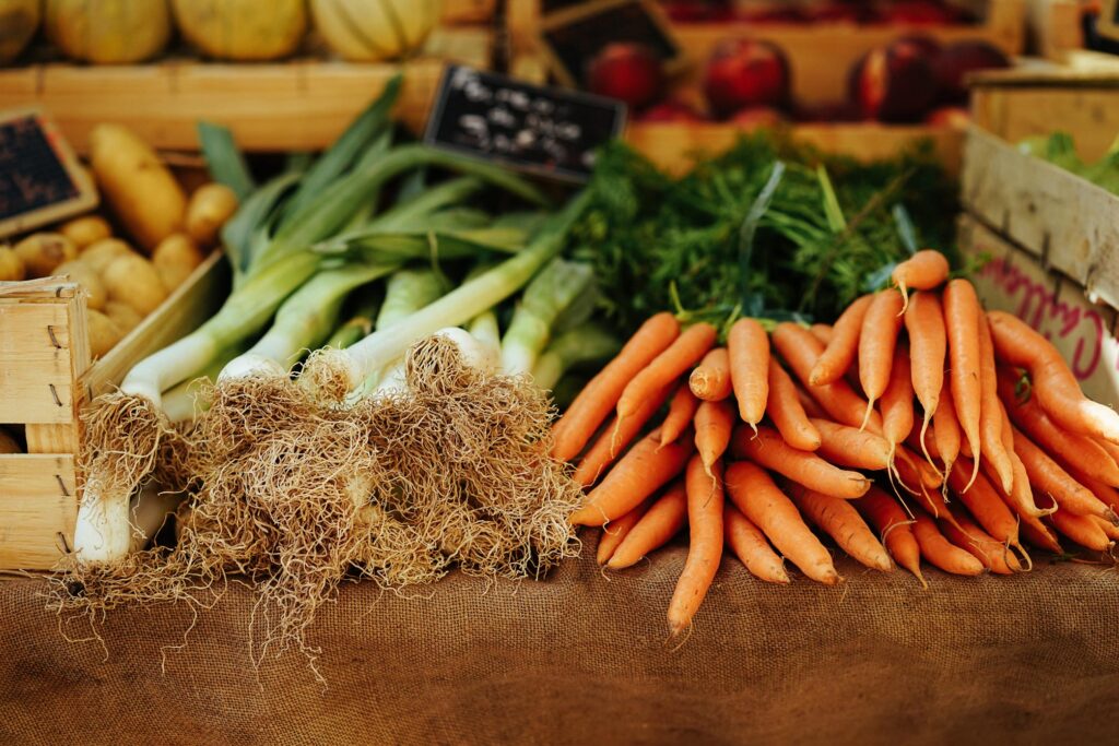 Table of fresh vegetables which include carrots and leeks.