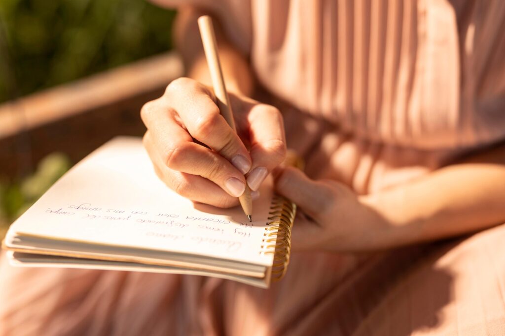 Close-up of women writing in her journal.